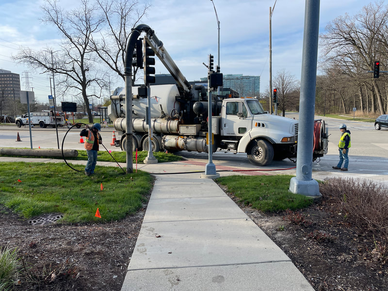 vacuum truck exposing utilities for temporary traffic signal installation at the northeast corner of Old Orchard Road and Woods Drive